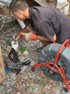 Brock with I Find Leaks pushing a ridgid sewer camera into a cleanout.