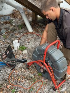 Brock with I Find Leaks using a Ridgid battery powered sewer camera to inspect a sewer line through a cleanout.